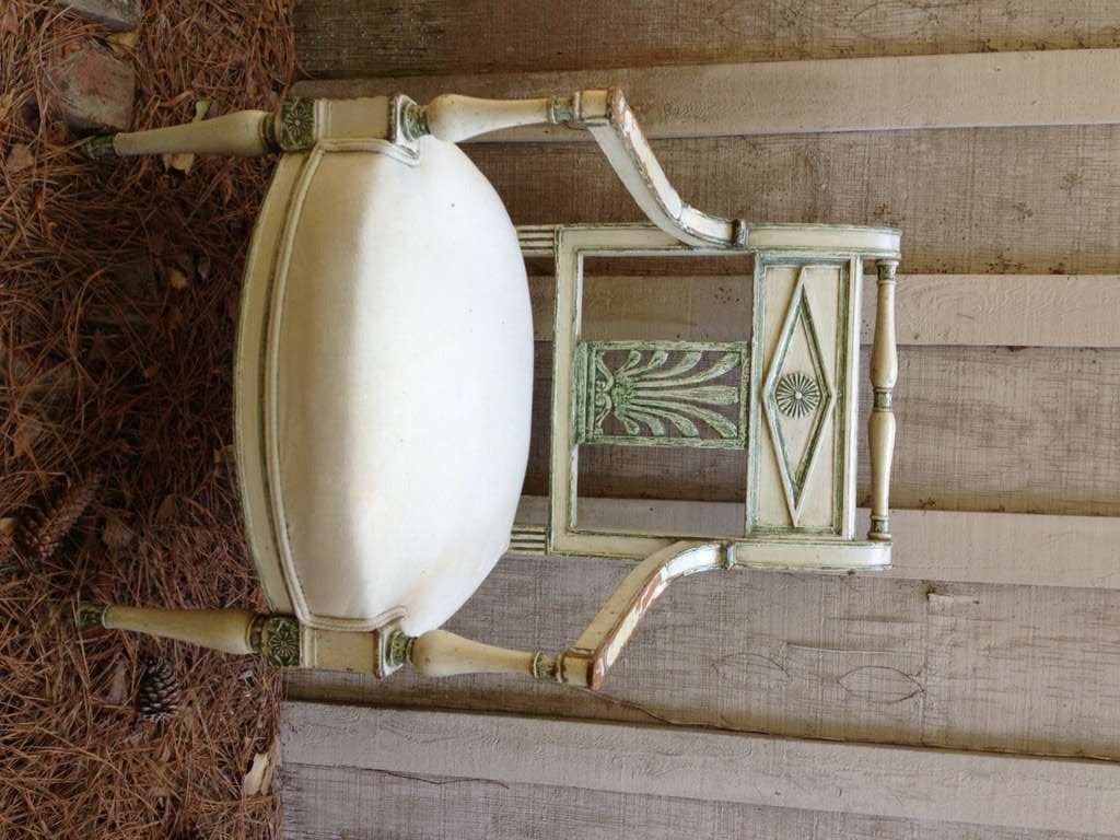 Pair of French Empire style fauteuils, cream paint with green accents, upholstered muslin seats.