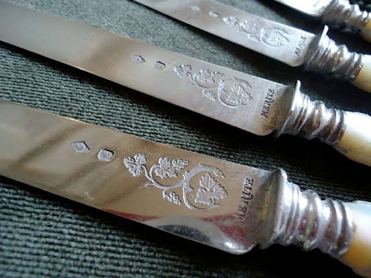 34 silver and mother-of-pearl French fruit or tea knives in original box. 17 blades are incised with a floral pattern above the silver collar and 17 blades are plain. The mother-of-pearl handles are identical for all 34 knives. 

The silver is