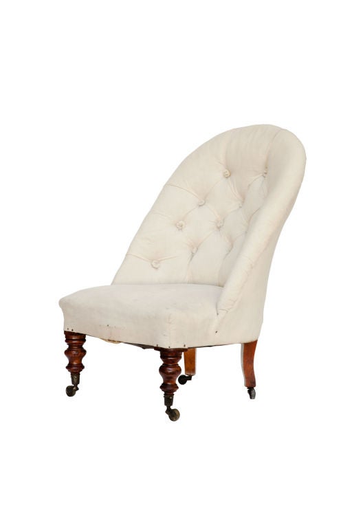 Tuft-back nursing chair with mahogany turned legs, brass castors.  Seat is 11
