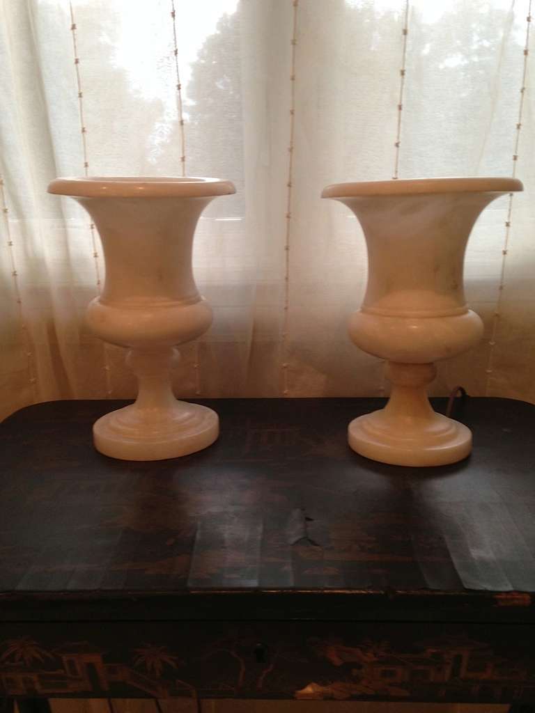 Pair of Alabaster urns wired as lamps. Takes chandelier bulb; silk flex cord with online switch.