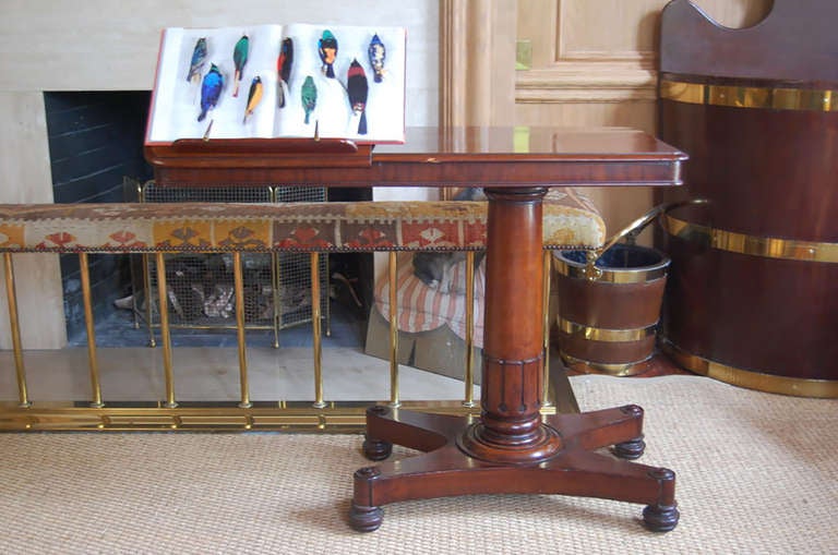 Mahogany William IV library/reading table on a pedestal resting on a quatreform base with turned feet. There are two adjustable ratcheted surfaces, which fold flat on table surface when not in use.