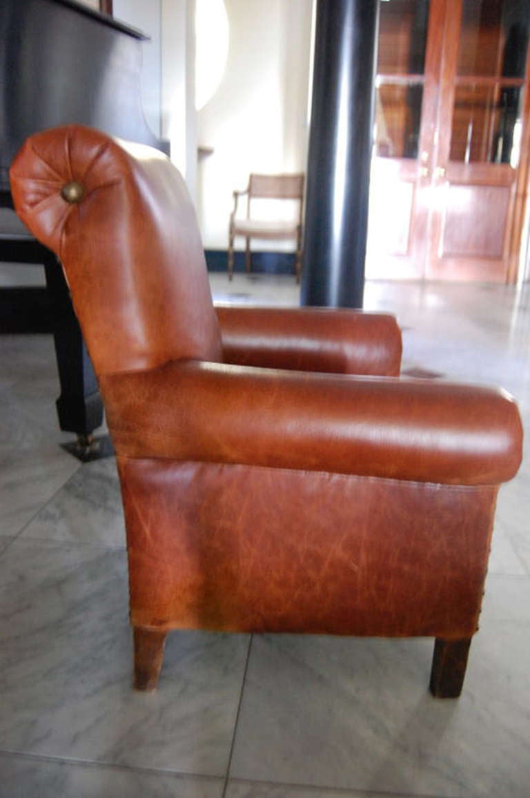 Child's leather club chair with brown aged leather upholstery and brass nailheads; straight legs. New leather upholstery in 2000.