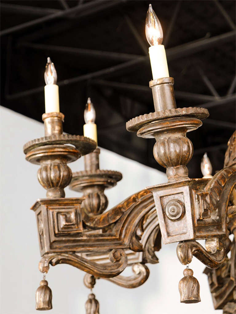 The central baluster fluted and carved with acanthus issuing eight arms with modified Greek key and rosettes draped with tassels.
