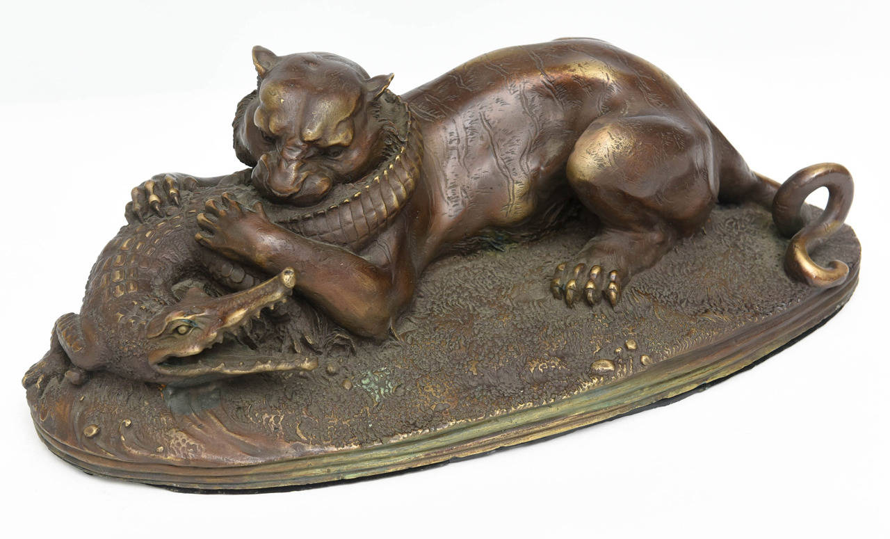 The oval base depicting a grassy area with a poised cougar wrestling a crocodile, signed Jules Moigniez.
