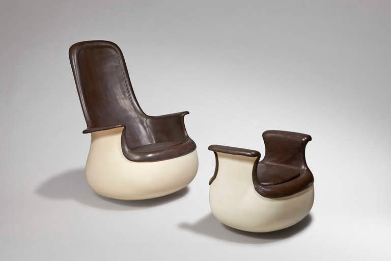 Armchair with high backrest, set on a round base that allows it to rock. Molded polyester shell reinforced with fiberglass and with interior weight. Upholstered in brown leather with foam stuffing.

Ottoman : Height : 53 cm ; Length : 65 ; Depth :