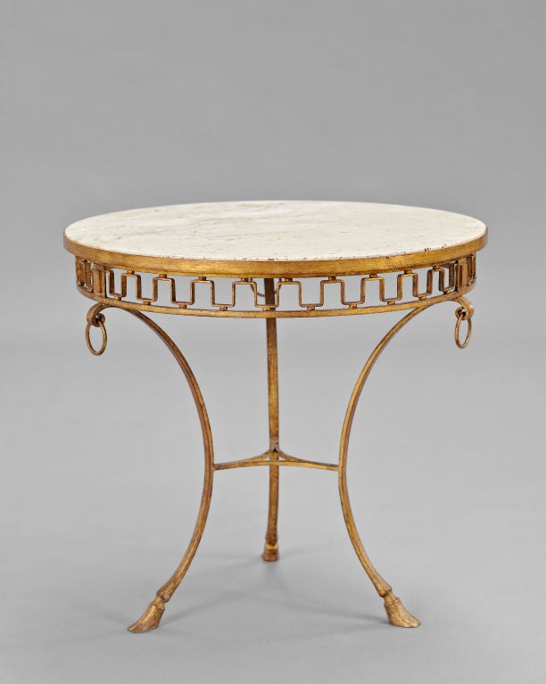 Original tripod structure in gilded wrought iron<br />
Crowbars surmonted by rings, holding an adjustable basket with openwork volutes<br />
Circular top in beige travertin marble resting on a belt in greek frieze