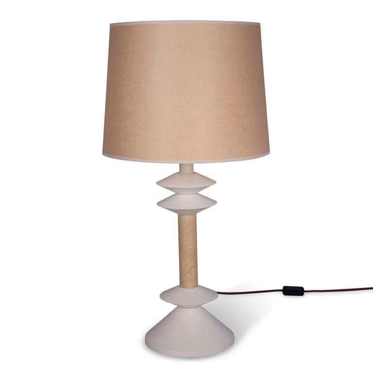 White lacqured steel table lamp, disc shaped elements separated by a reed wrapped middle column section. Designed by Jay Spectre for Paul Hanson, circa 1980. Overall height 31 1/2 in, bottom of base 9 in diameter, discs 6 in diameter. Shade measures