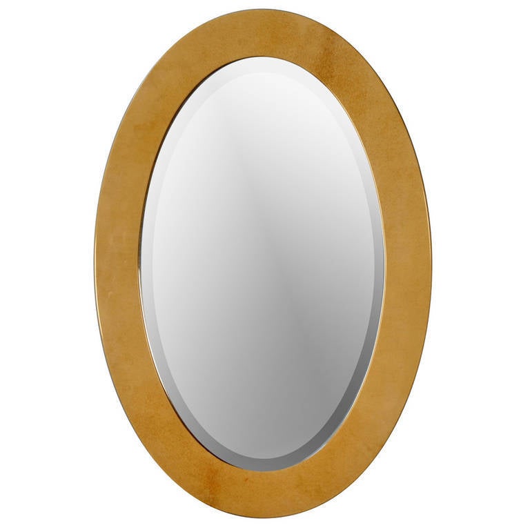 Lacquered goatskin mirror, of oval shape, and having beveled edge mirrored glass, by Aldo Tura, Italian 1960s. Retains original label to back. 31 in x 21 in, depth 3/4 in. (Item #1821)
