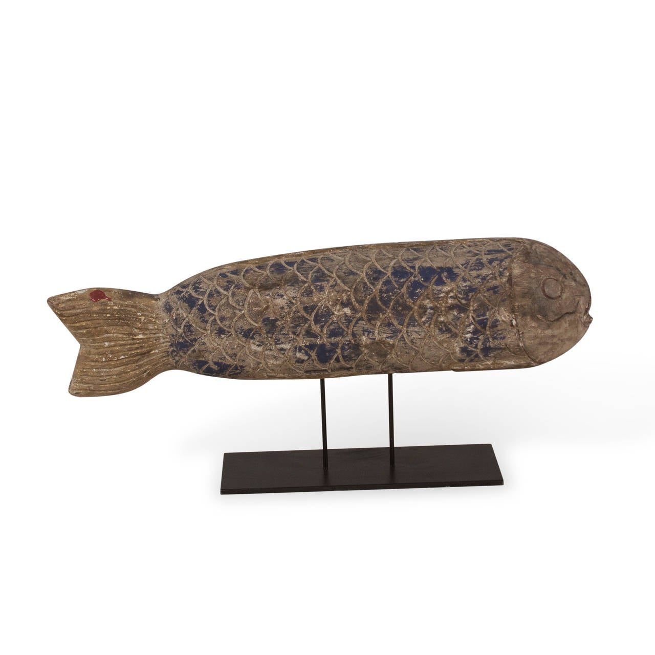 Sculptural wooden fish mounted on iron stand, carved scales, fins, eyes and mouth, some blue faded blue paint remains on body, wax seal stamp on tail, Chinese, early 20th century. Measures: Length 20 1/2 in, diameter of fish 5 1/2 in. Bottom of base