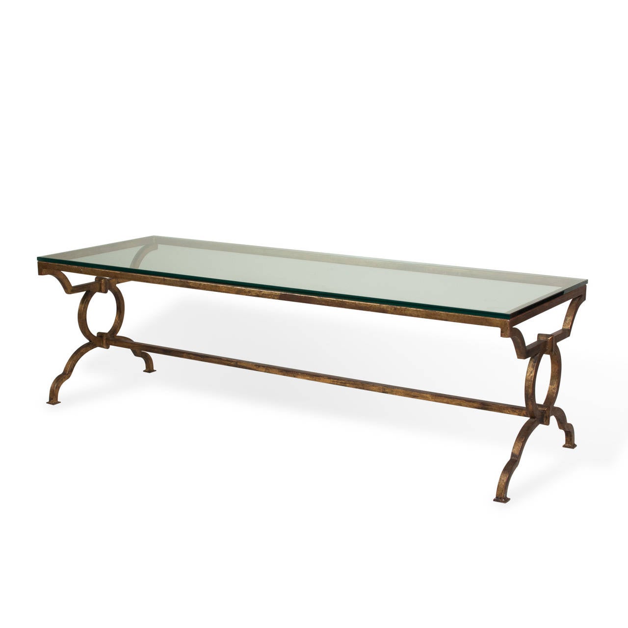 Gilt iron coffee table, with curved legs, end circle elements and cross stretcher, clear glass top, French, 1960s. In the style of Ramsay. Dimensions: Length 60 in, width 24 in, height 16 1/2 in. (Item #2276).