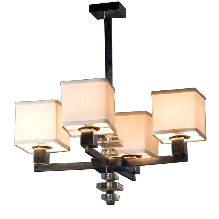 Four arm nickeled bronze chandelier, with square stock frame, cube shaped light holders, and square glass discs in column. In the style of Jacques Adnet, French 1930s. 23 in x 23 in square, overall height 23 1/2 in. Shades measure 5 in cubed. (Item