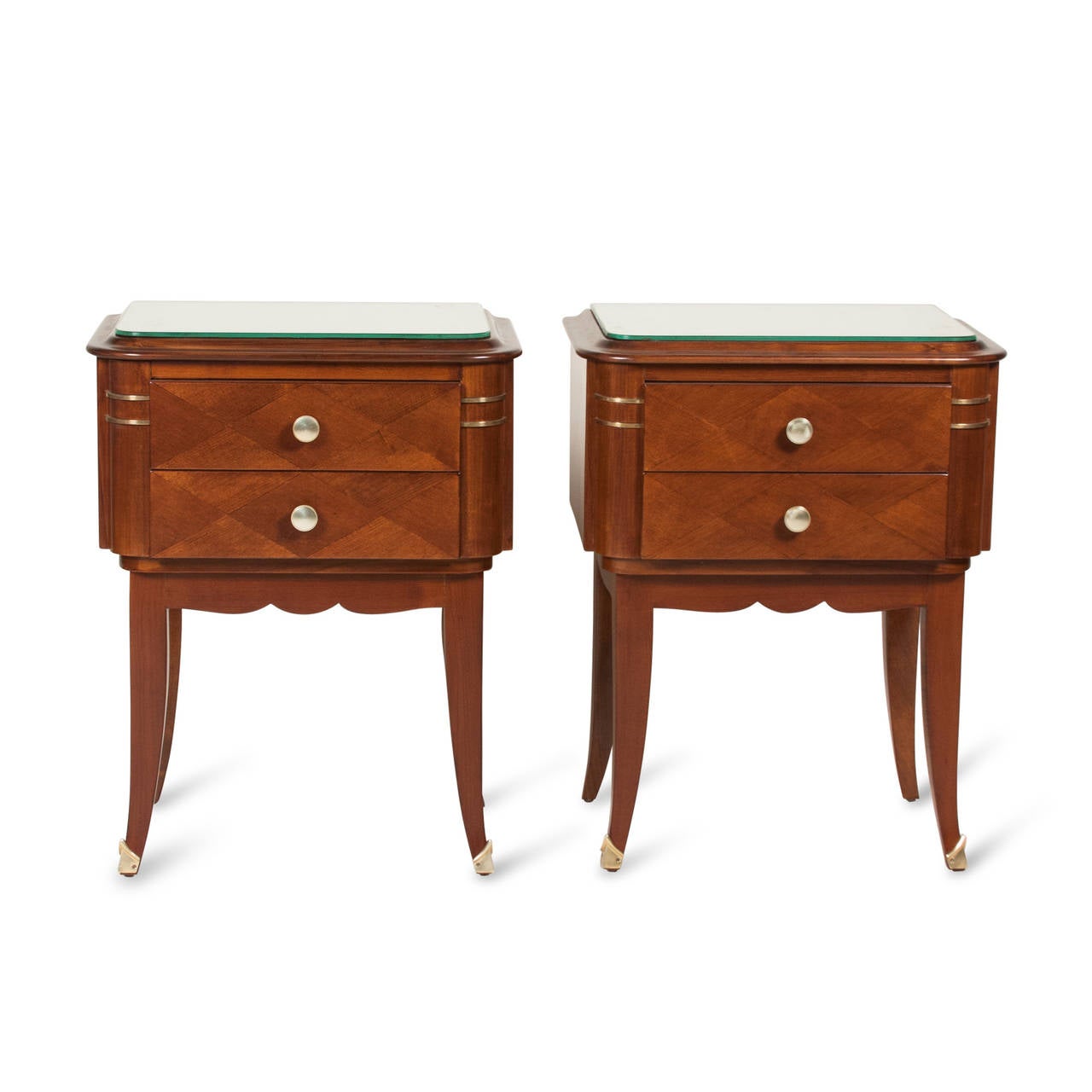 Pair of darkened sycamore two drawer end tables, with diamand marquet faces, brass pulls, the case mounted on arced legs with bronze sabots, shaped antiqued mirrored glass tops, French late 1940s. Height 24 1/2 in, width 20 in, depth 13 in. (Item