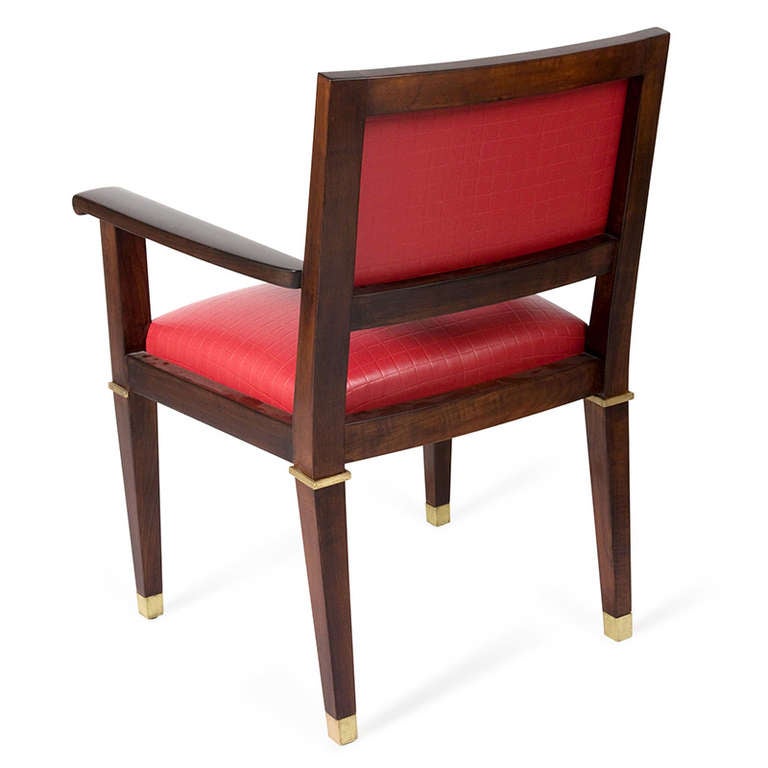 Acajou desk chair, with bronze dore accents and sabots, the legs gracefully tapered, the seat and rectangular shaped back upholstered in a high quality Kravet red grid pattern vinyl, by Jacques Adnet, French circa 1950. Back height 35 1/2 in, seat