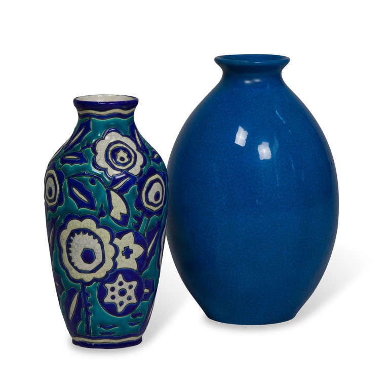 Two vases, sold as a set or separately. 
On left: Blue and white flower decorated vase with wide opening, over a turquoise base, in crackle glaze, by Keramis, Belgian, circa 1925. Signed to underside. Height  11 in. (Item #2026)
On right: Tall