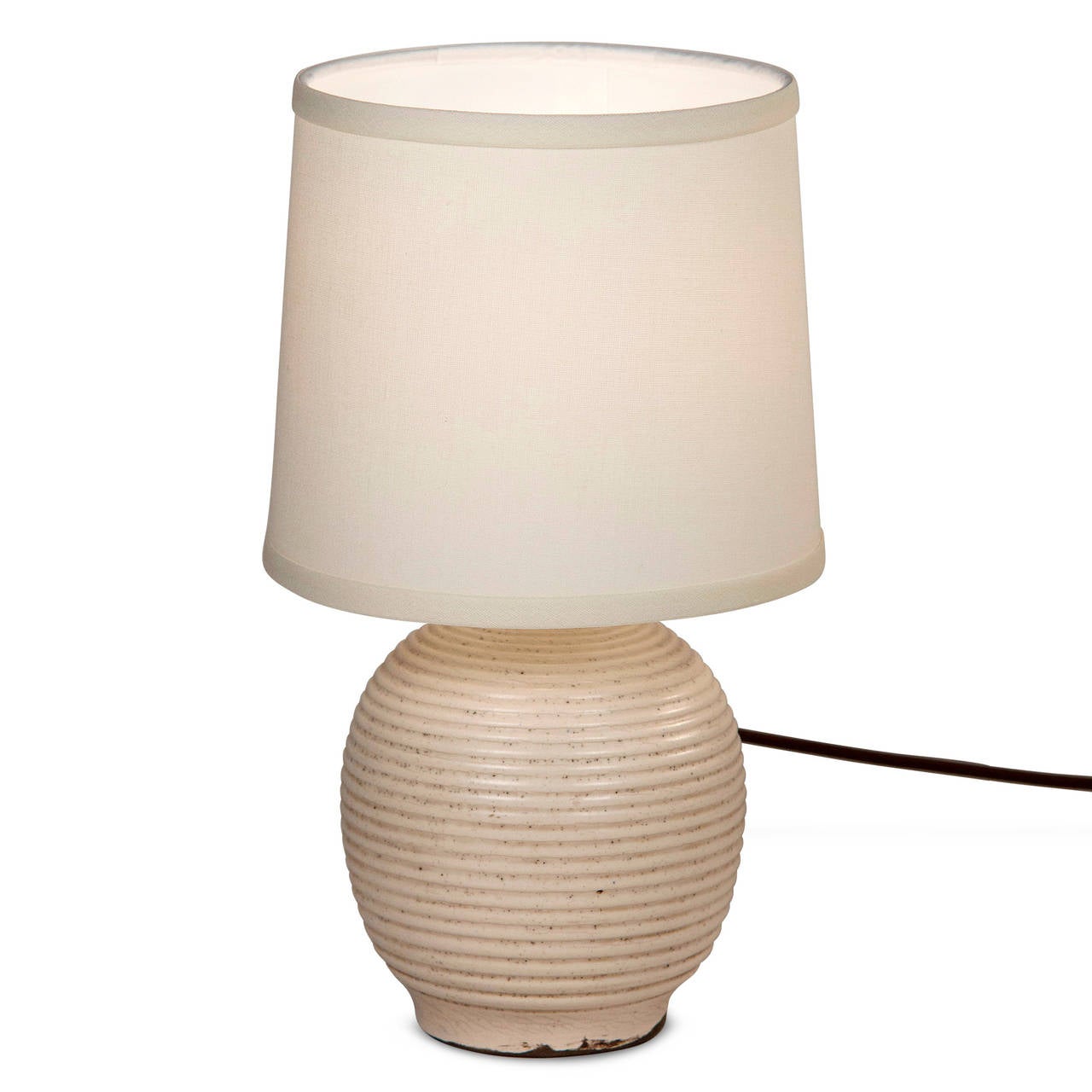 Glazed bulbous form ceramic table lamp, with circular grooves around the body, in custom silk shade, in pale off-white glaze, by Keramos for Sevres, French 1950s. Signed to underside. In custom silk shade. Overall height 14 in, diameter of base 6