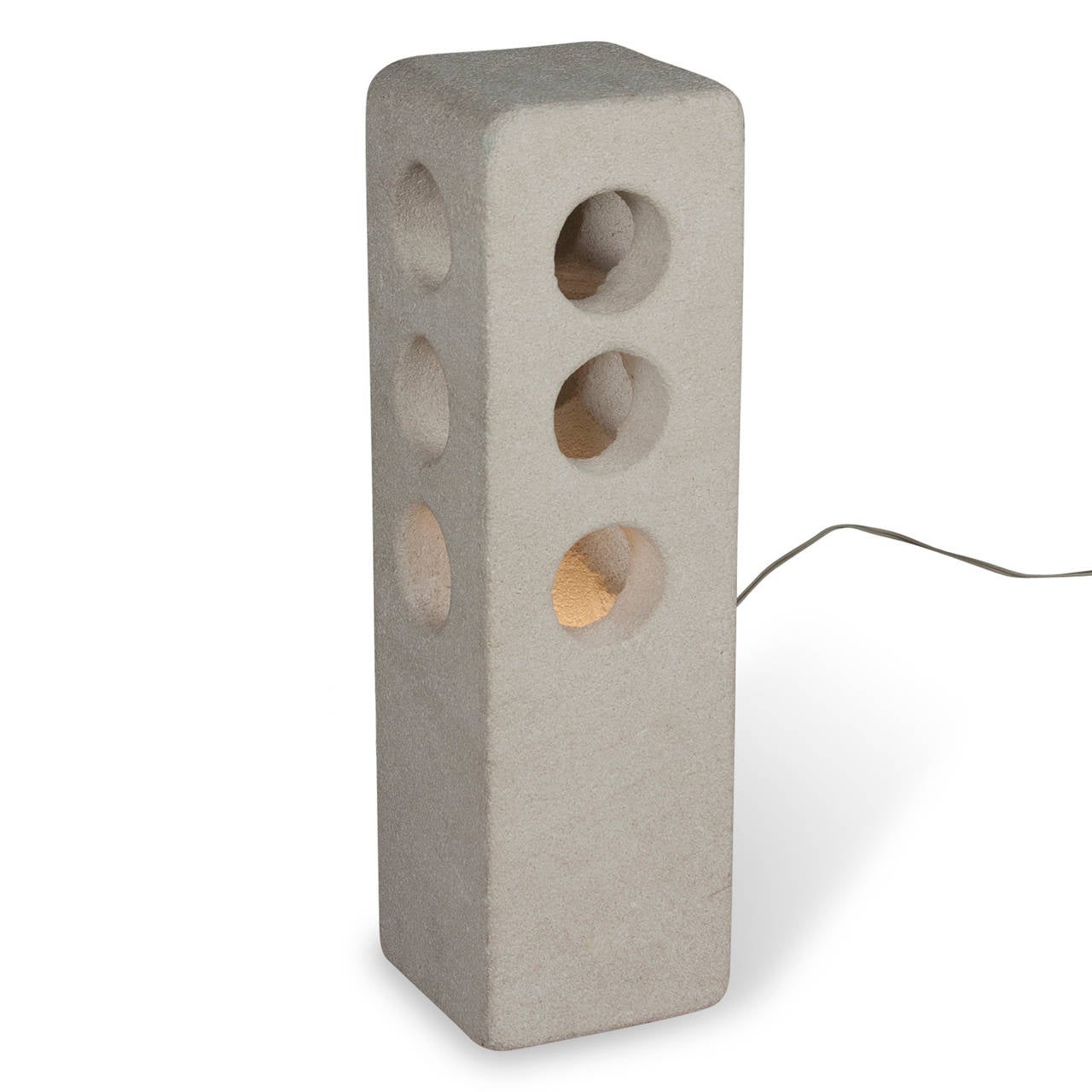 The sculpted stone column lamp, the rectangular form having three circular openings on each side, by A. Tormos, French, circa 1970. Signed 