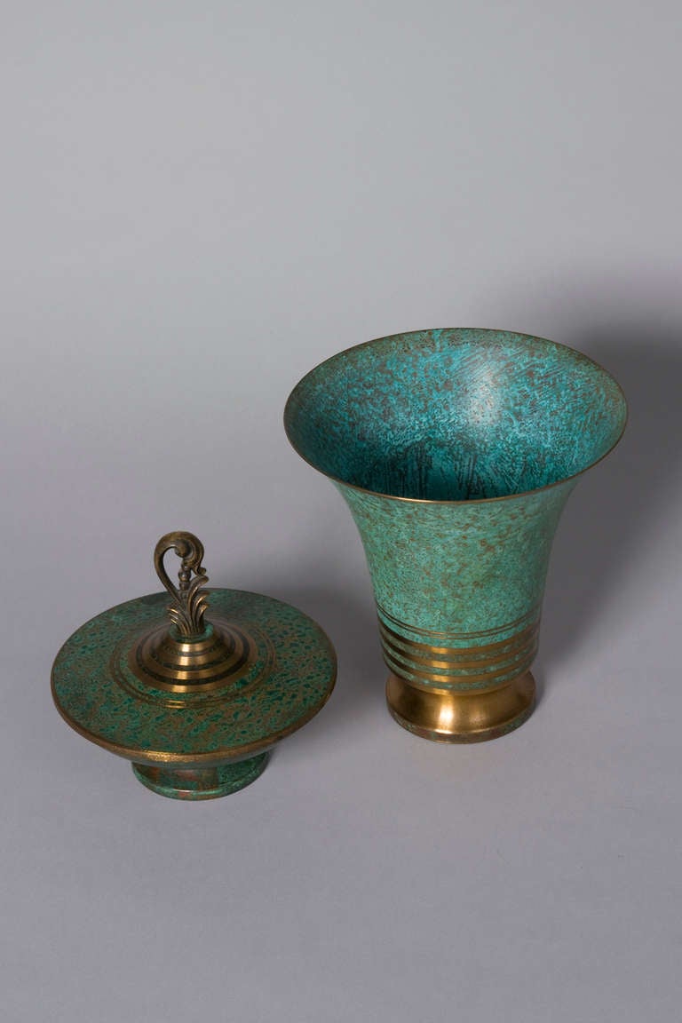 Two verdigris bronze objects, a trumpet form vase with bronze colored bands at bottom, and lidded dish with bronze decorative handle, by Carl Sorensen, American, circa 1920. Signed. Height of vase 7 1/2 in, top diameter 7 1/8 in, bottom diameter 3