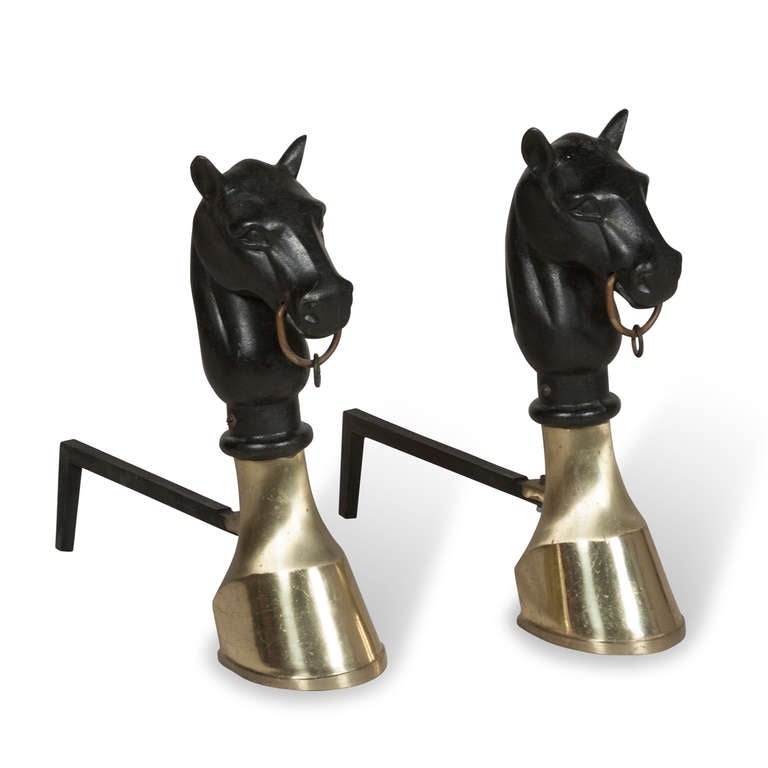 Pair of iron horse head form andirons, with thick brass hoof form base, black sculptural horse head having brass ring in mouth, American 1960s. Height 17 1/2