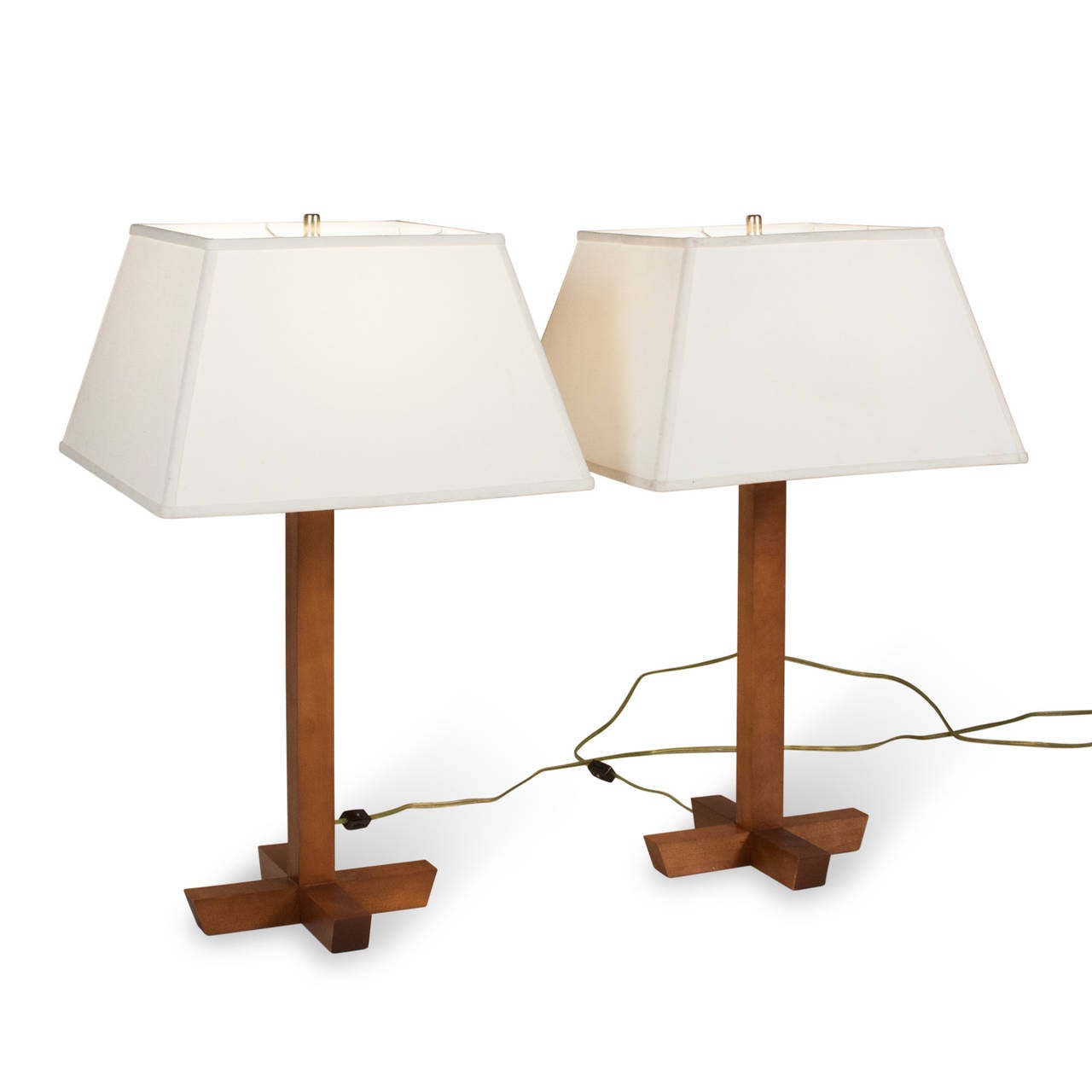Pair of walnut table lamps, a single square column mounted on an X-base of walnut, American, 1970s. Overall height 27 in, base measures 10 in square. Height to top of socket 19 1/2 in. Wood is 1 1/2 in square. Linen shade measures top 11 1/2 in
