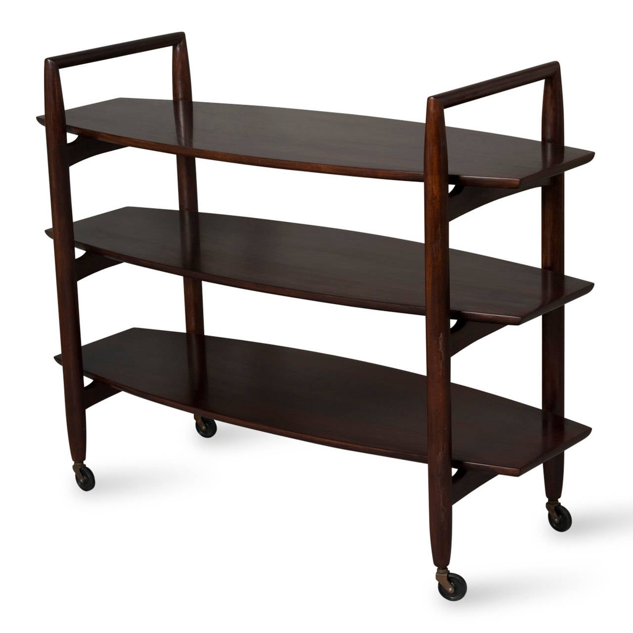 Three tier mahogany rolling shelf, slightly oval shaped shelves, inverted U shaped supports, by T.H. Robsjohn-Gibbings for Widdicomb, American 1950s. Length 46 in, depth 16 in, height to top shelf 30 in, height to top of arm 35 1/2 in. (Item #2132)