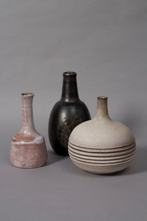 Group of three ceramic vases, sold as a group or separately. From left to right - <br />
1) Washed white glaze long neck ceramic vase, with sgraffito markings throughout surface, by Juliette Derel, French circa 1960. Signed to underside. Height 9