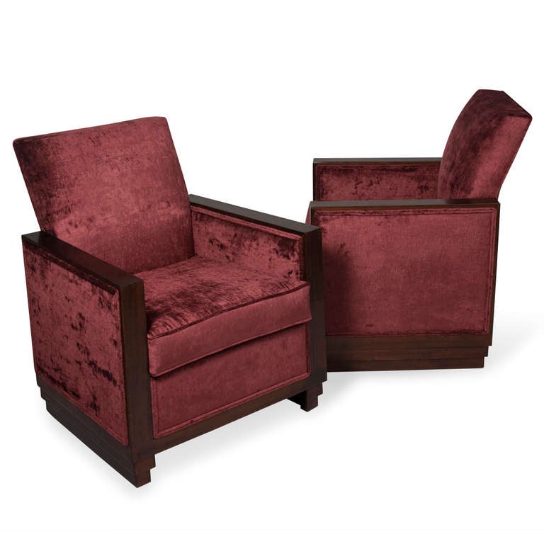 Pair of mahogany frame armchairs, with raised backs, the mahogany wrapping around the entire border of the sides, on stepped bases, French 1930s. Newly upholstered in a deep burgundy velvet blend. Back height 36 in, width 29 1/2 in, depth 25 1/2 in.