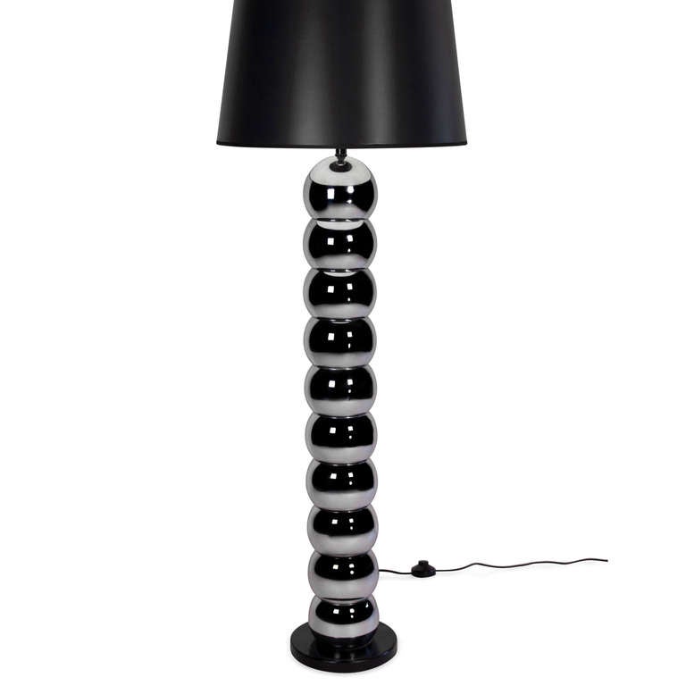 Stacked chrome ball floor lamp, with circular black base, American 1960s. In custom black paper shade. Overall height 57 in, base has 9 in diameter, ball have 6 in diameter. Shade measures top diameter 16 in, bottom diameter 20 in, height 13 1/2 in.