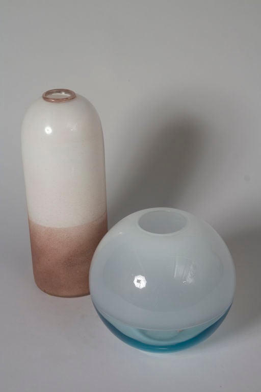 Two murano glass vases, sold separately. <br />
On left) Cylindrical bullet shaped glass vase, in opaque white glass, with reddish brown top rim and lower body, and having faint metallic lustre finish. By Vittorio Rigattieri for Seguso Vetri