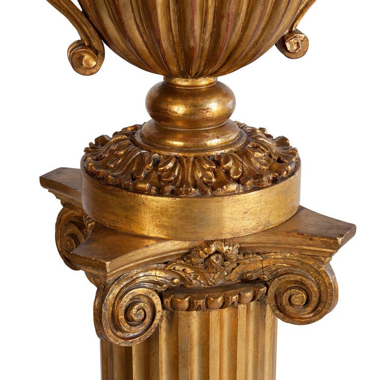 Giltwood floor lamp, the fluted column having square base, with urn-form mounted on top of column, American, 1930s. In custom black paper shade with gold foil lining. Overall height 76 in, height from floor to bottom of shade 60 in, base at floor