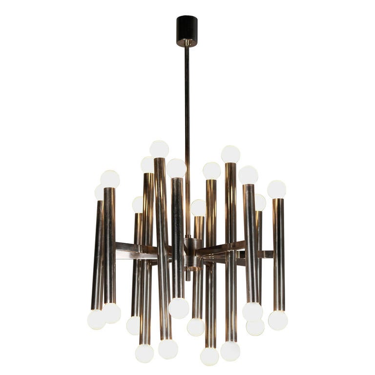 Twenty-four-light chrome chandelier, twelve vertical posts, in two different lengths, attached to center column by twelve arms. Italian, 1960s. Diameter 22 in, height from bulb to bulb 21 1/2 in, overall height 38 in.