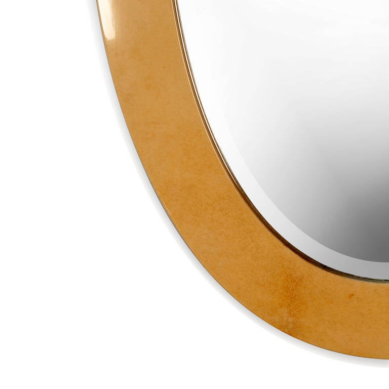 Lacquered goatskin mirror, of oval shape and having beveled edge mirrored glass by Aldo Tura, Italian, 1960s. Retains original label to back. Measures: 31 in x 21 in, depth 3/4 in.