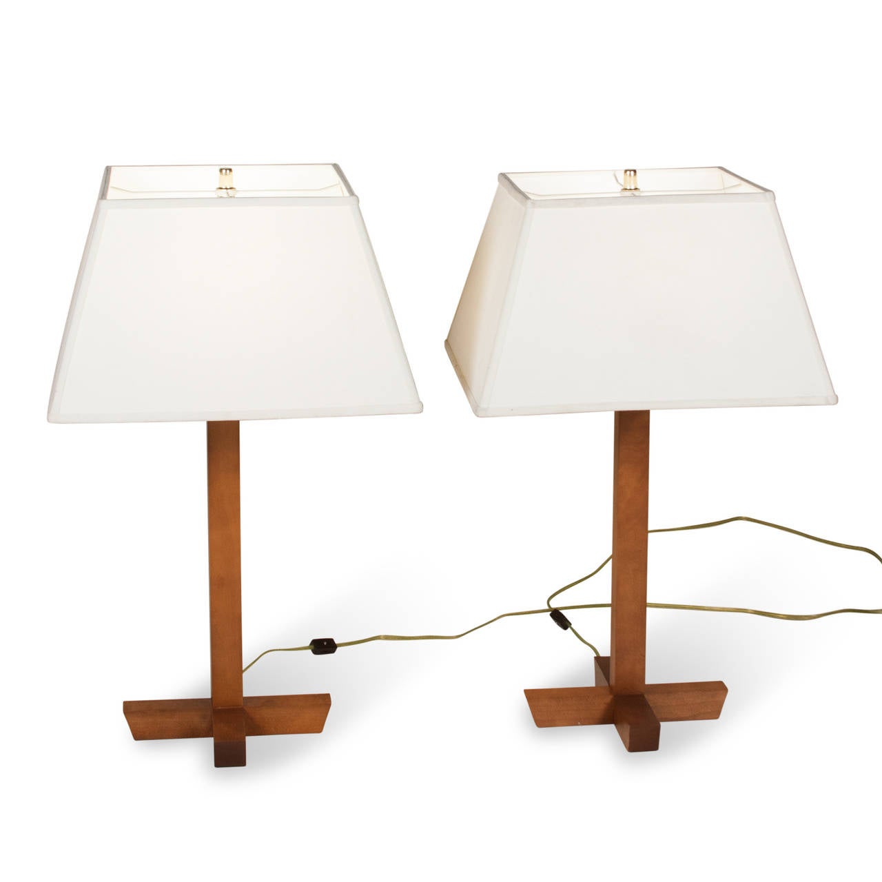 Pair of walnut table lamps, a single square column mounted on a x-base of walnut, American 1970s. Overall height 27 in, base measures 10 in square. Height to top of socket 19 1/2 in. Wood is 1 1/2 in square. Shade measures top 11 1/2 in square,