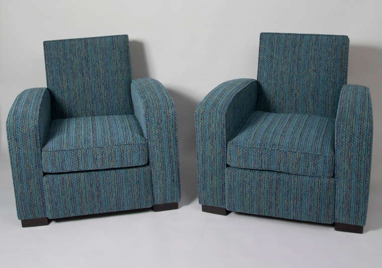 Pair of upholstered club chairs, with arced arms, resting on four block wood feet, by Jacques Adnet, French 1930s. Upholstered in a Kravet blue/green woven cotton blend chenille. Back height 31 in, seat height 16 1/2 in, arm height 23 1/2 in, width