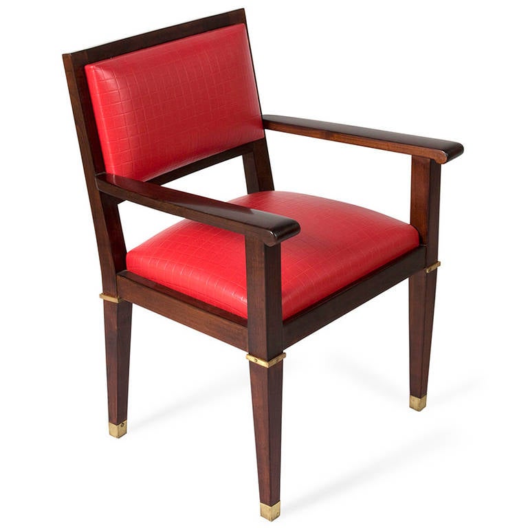 Acajou desk chair, with bronze dore accents and sabots, the legs gracefully tapered, the seat and rectangular shaped back upholstered in a high quality Kravet red grid pattern vinyl, by Jacques Adnet, French circa 1950. Back height 35 1/2 in, seat