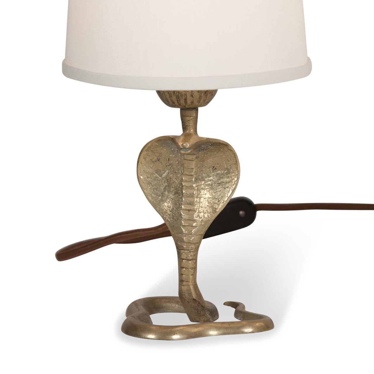 Pair of bronze cobra form tables lamps, the serpent standing with hood open, and body loosely coiled, French 1930s. In custom silk shades. Overall height 12 in, diameter of tail 4 in. Shade measures top diameter 5 in, bottom diameter 6 in, height 5