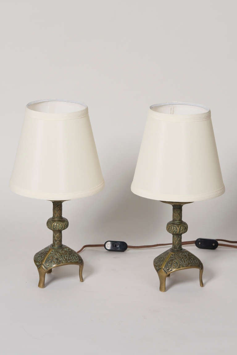 Pair of abstract motif decorated bronze boudoir or small table lamps, on three legs, in custom silk shades, by Max Le Verrier, French circa 1930. Signed. Overall height 15 1/2 in, base measures 4 1/2 in across at largest point, shade has top