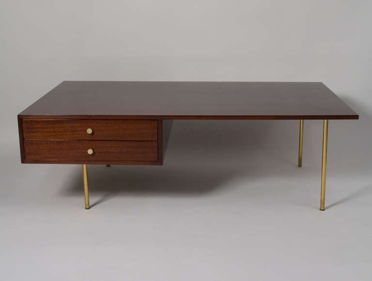 Solid mahogany rectangular coffee table, with two offset drawers having brass pulls, raised on four brass legs. Finished on all four sides. By Harvey Probber, American 1950s. 56 in x 32 in, height 18 in. (IItem #1700)