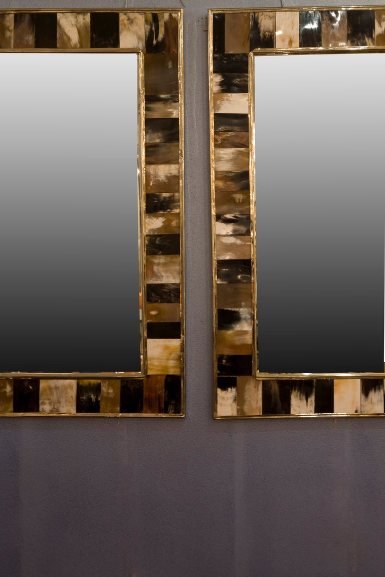 Pair of bone and horn framed mirrors, the different colors of white, bone, black, brown pieces arranged in a varying pattern, with brass outer and inner border, by Maitland Smith, English, 1970s. Each 33 1/2 in x 27 1/2 in. (Item #1666)