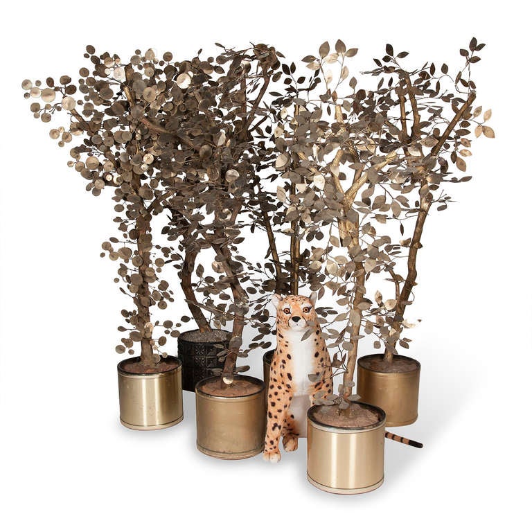 Set of six large brass and gilt painted wood tree sculptures, the leaves in patinated brass, attached to genuine wood tree set into a resin material in cylindrical pots. Some of the trees have disc shaped leaves, others have leaf shaped leaves, by