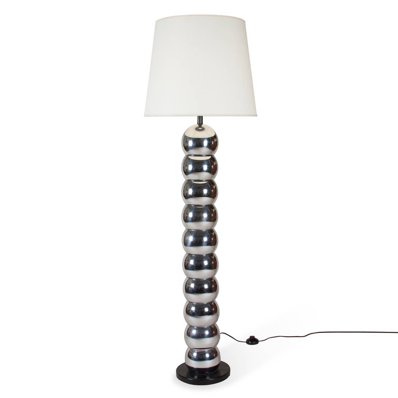 Stacked chrome ball floor lamp, with circular black base, American, 1960s. In custom black paper shade. Overall height 57 in, base has 9 in diameter, ball have 6 in diameter. Shade measures top diameter 16 in, bottom diameter 20 in, height 13 1/2 in.