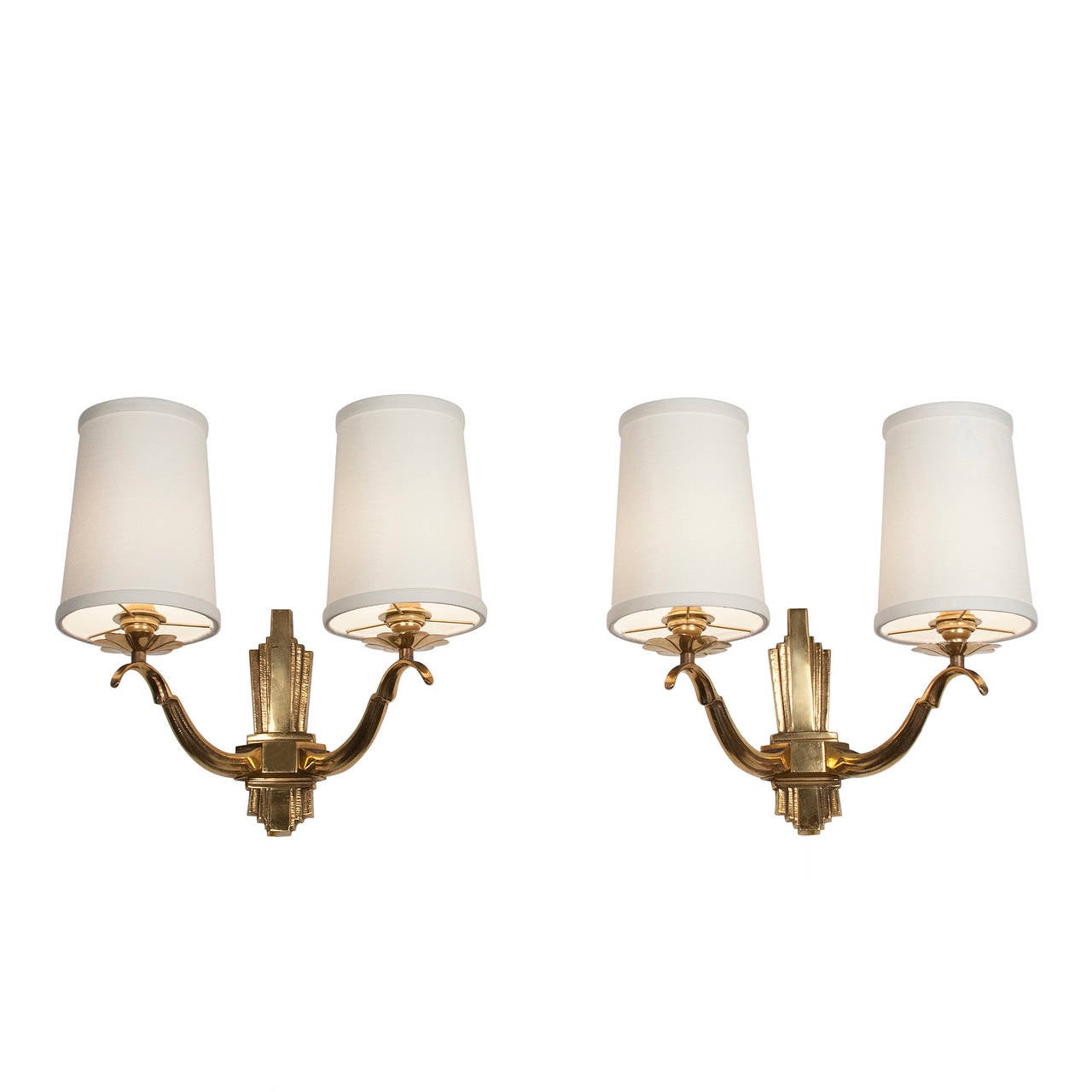 Pair of two-arm bronze sconces, curved S-shaped arms joining at center stepped shield wall mount, French, 1940s. In custom silk shades, height 13 1/2 in, width 14 in, depth 7 3/4 in. Shade measures top diameter 4 in, bottom diameter 5 in, height 6
