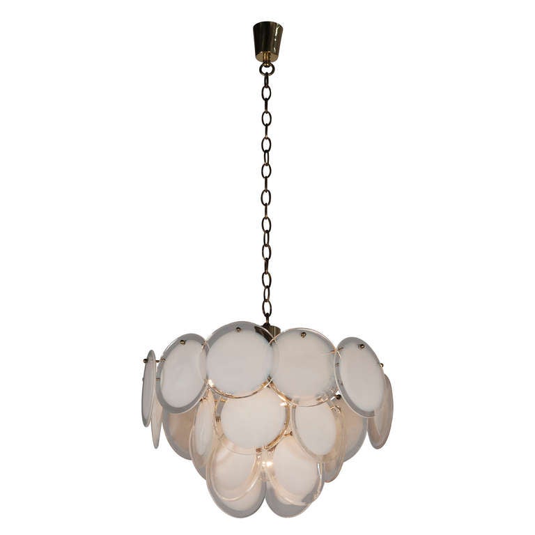 Circular chandelier with hanging white glass discs, each disc having a clear border and arranged in three tiers, suspended from a brass frame and rod, Italian 1960s. Diameter 18 in, height of fixture with glass parts only 16 in. Overall height