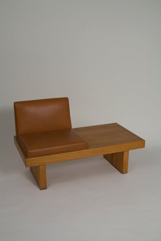 Oak single seat platform bench, the surface resting on two oak supoorts, the vinyl upholstered seat having a back. By Harvey Probber, American 1950s. Length 47 1/4 in, depth 24 in, height of platform 14 1/2, width of seat 22 in, seat height 18 in,