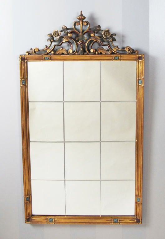 A very decorative 1930's mirror in gilt wood with colored enamel accents.  Mirror is reserved etched.