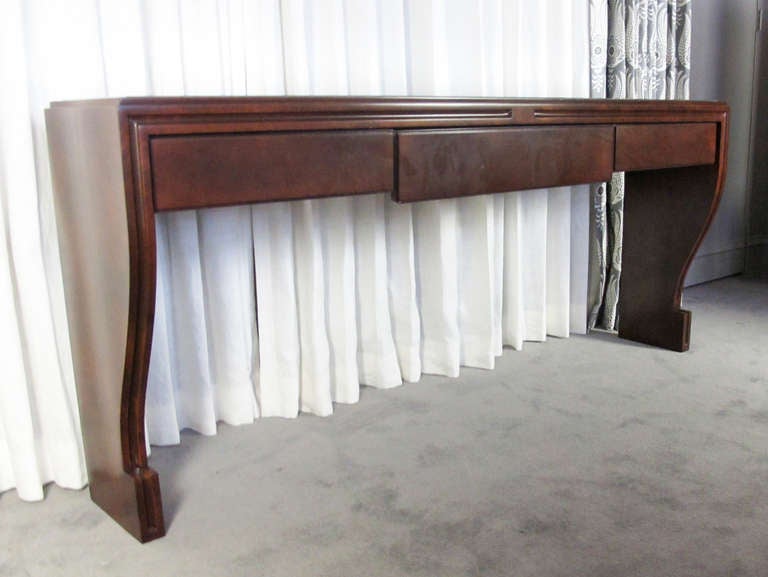 An elegant sideboard or credenza designed by Tommi Parzinger for Parzinger Originals.  Features and single center drawer and retains original mirrored top.  Although not signed, this piece was authenticated by Parzinger's partner, Donald Cameron,
