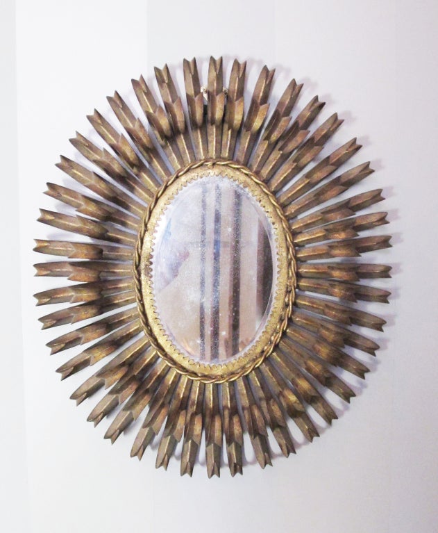 A very decorative and elegant metal eyelash mirror made in Spain during the mid-century. This mirror is reminiscent of Italian metal work or the designs of Curtis Jere.
