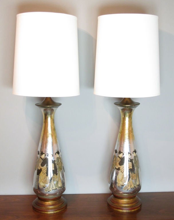 A large pair of reverse-decorated and silvered lamps depicting Japanese women in traditional wardrobe.  Lamps are designed for a crimped wire shade to fit into a glass diffuser, however, neither is included with the lamps.  With the shades shown,