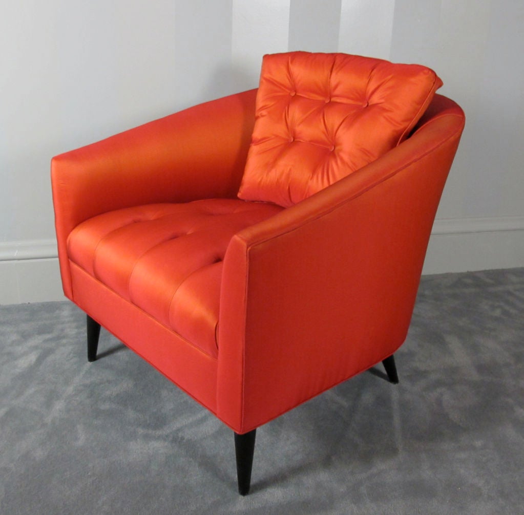 A sexy and glamorous pair of smaller-scaled chairs with a tufted tight seat and buttoned loose back pillow.  Reupholstered to original specifications in an orange/red silk-blend fabric.  Legs refinished in a dark expresso color.