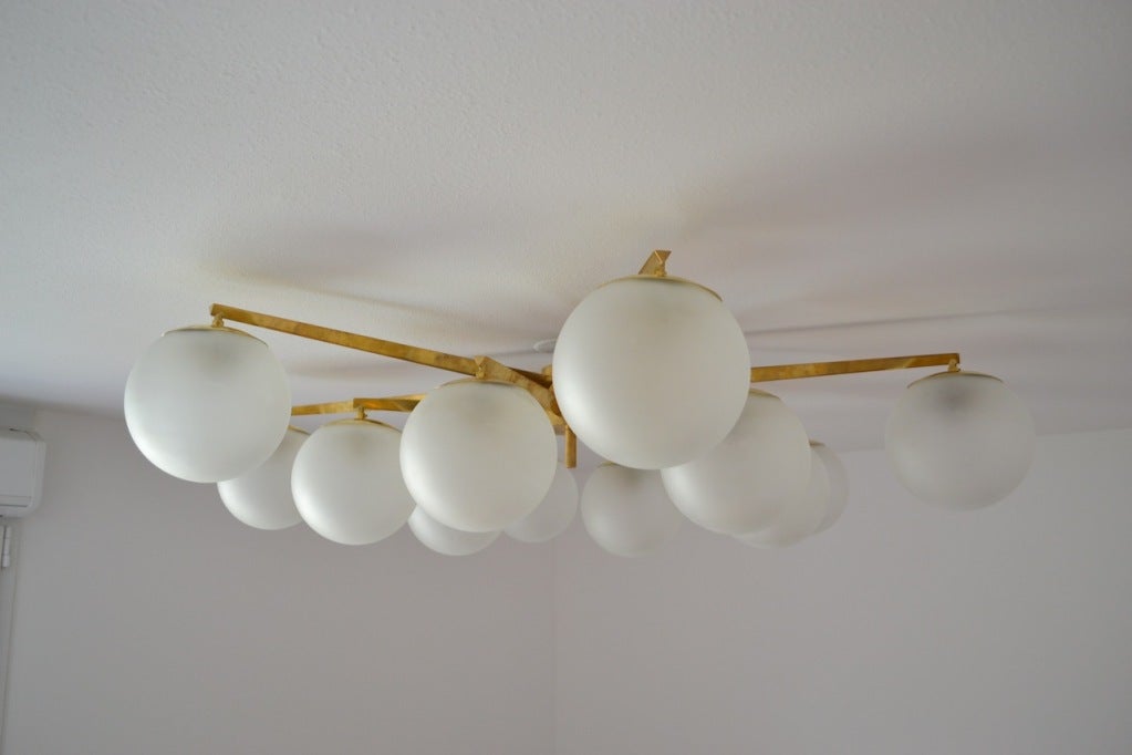 STELLA
Italy 1950 sItalian Chandelier by Angelo Lelli for ArredoluceTwelve Frosted Glass Globes Connected to Twelve Bronze Arms