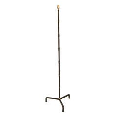 A black leather covered floor lamp by JACQUES ADNET